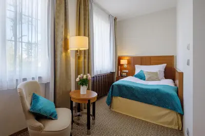 a hotel room with a bed and a chair at Hotel Silenzio in Prague