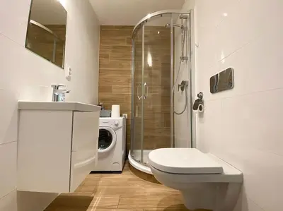 a bathroom with a toilet and a washing machine at Parkside Studio in Vinohrady in Prague
