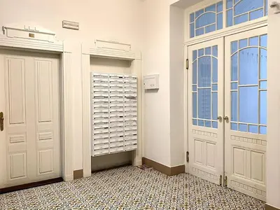 a garage with two white doors and a tiled floor at Parkside Studio in Vinohrady in Prague