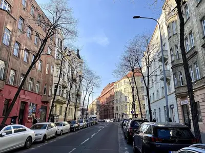 a city street with cars parked on the side of the road at Parkside Studio in Vinohrady in Prague