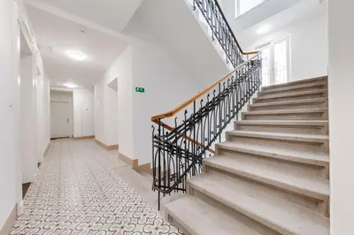 a staircase in a home with white walls and a white floor at Parkside Studio in Vinohrady in Prague