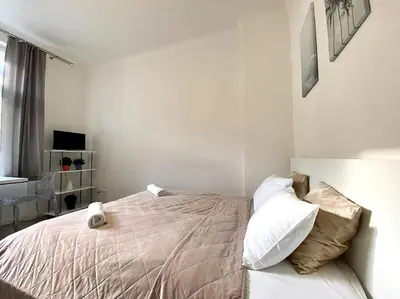 a bedroom with a bed with white sheets and pillows at Parkside Studio in Vinohrady in Prague