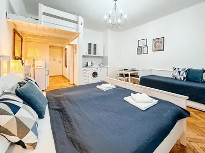a bedroom with a large bed and a kitchen at ELSO center apartment in Prague