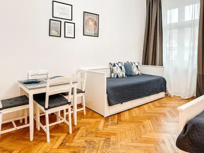 a bedroom with a bed and a desk and a table at ELSO center apartment in Prague
