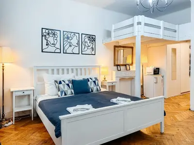 a bedroom with a white bed and a loft bed at ELSO center apartment in Prague