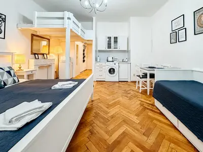a bedroom with a bed and a kitchen and a dining room at ELSO center apartment in Prague