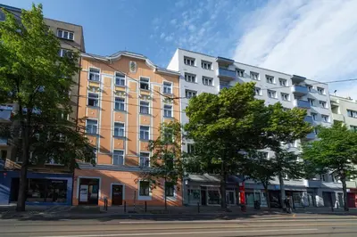 a building on a street with trees in front of it at Hotel Leon in Prague