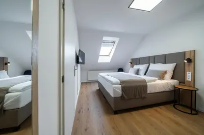 a bedroom with two beds and a skylight at Hotel Leon in Prague