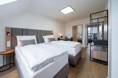 a hotel room with two beds and a mirror at Hotel Leon in Prague