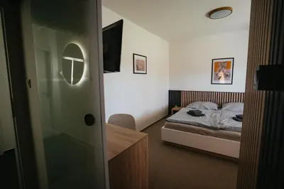 a small bedroom with a bed and a glass door at Penzion Tsport in Wotitz