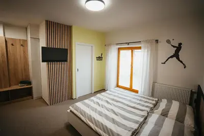a bedroom with a bed with a tennis player on the wall at Penzion Tsport in Wotitz