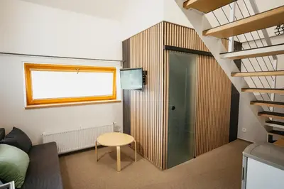 a living room with a staircase and a glass door at Penzion Tsport in Wotitz