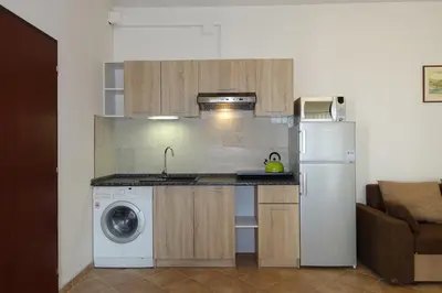 a kitchen with a washing machine and a refrigerator at Green Club in Tursko
