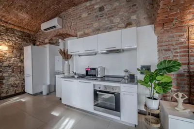 a kitchen with white cabinets and a brick wall at Centre Prague Retreat Residence in Prague