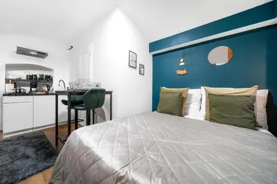 a bedroom with a large bed with a blue headboard at Secret Economy Studio Oasis in Prague