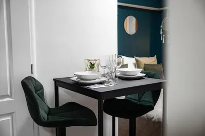 a black table with two chairs and glasses on it at Secret Economy Studio Oasis in Prague