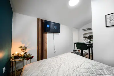 a bedroom with a bed and a desk and a kitchen at Secret Economy Studio Oasis in Prague