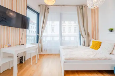 a bedroom with a white bed and a desk at New-built Golden Luxury Studio with Balcony in Prague