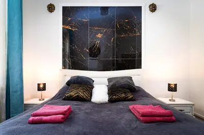a bedroom with a bed with two red pillows at Grand Deluxe Suite in Prague