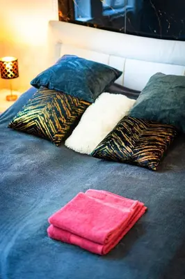 a bed with two pillows and a towel on it at Grand Deluxe Suite in Prague