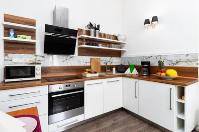 a kitchen with white cabinets and wooden counter tops at Grand Deluxe Suite in Prague