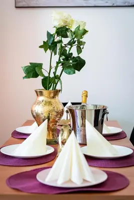 a table with white plates and a vase with a flower at Grand Deluxe Suite in Prague