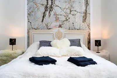 a bedroom with a white bed with two pillows on it at Grand Deluxe Suite in Prague
