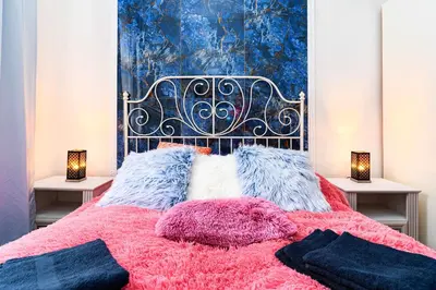 a bedroom with a bed with pink and blue at Grand Deluxe Suite in Prague