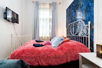 a bedroom with a bed with a red blanket at Grand Deluxe Suite in Prague