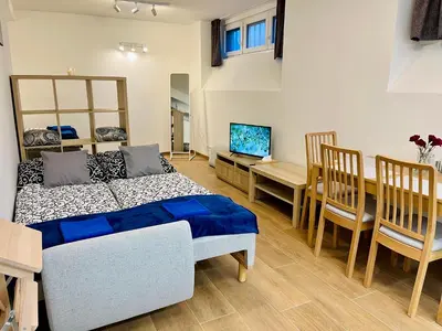 a bedroom with a bed and a dining room with a table at Pleasant Basement Apartment in Prague
