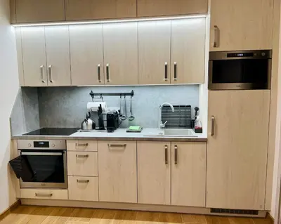 a kitchen with white cabinets and a stove top oven at Pleasant Basement Apartment in Prague