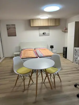 a dining room table with four chairs and a bed at Relax pobyt na břehu Sázavy a na dosah Prahy in Čerčany