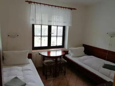 a bed with white sheets and pillows in a bedroom at Penzion Janata in Slapy