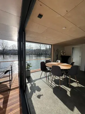a dining room with a table and chairs on a deck at Prague Stream in Prague