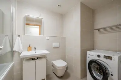 a bathroom with a washing machine and a sink at Garden Studio near Metro Kolbenova in Prague
