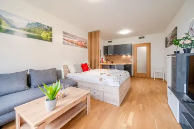 a living room with a bed and a couch at Garden Studio near Metro Kolbenova in Prague