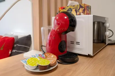 a red mixer sitting on a counter next to a microwave at Garden Studio near Metro Kolbenova in Prague