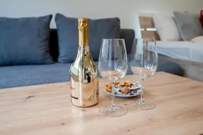 a bottle of champagne and two wine glasses on a table at Garden Studio near Metro Kolbenova in Prague