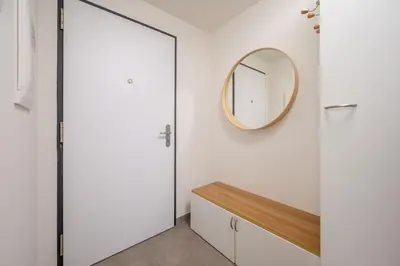 a bathroom with a mirror and a white wall at Garden Studio near Metro Kolbenova in Prague
