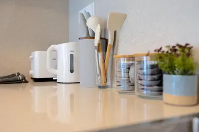 a counter with utensils in cups on a counter top at Colorful Apartment - Balcony, Free Parking, by Gravity Prague in Prague