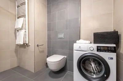 a bathroom with a washing machine and a toilet at Colorful Apartment - Balcony, Free Parking, by Gravity Prague in Prague