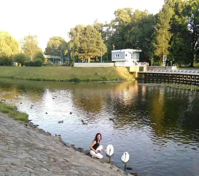 a woman sitting in the water with three birds at Apartmán v srdci Poděbrad 100m2 in Poděbrady