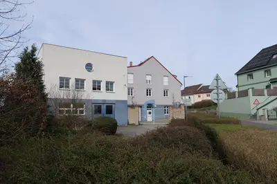 a white house with a blue door on a street at Ubytování Pod věží Hoštka u Roudnice nad Labem in Litoměřice