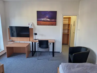 a room with a desk with a television and chairs at Ubytování Pod věží Hoštka u Roudnice nad Labem in Litoměřice