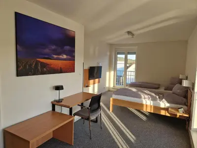 a bedroom with a bed and a desk and a couch at Ubytování Pod věží Hoštka u Roudnice nad Labem in Litoměřice