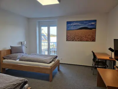 a bedroom with a bed and a desk and a window at Ubytování Pod věží Hoštka u Roudnice nad Labem in Litoměřice
