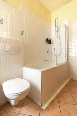 a bathroom with a toilet and a tub and a shower at NELIS I Boutique Apartments in Old Town in Prague