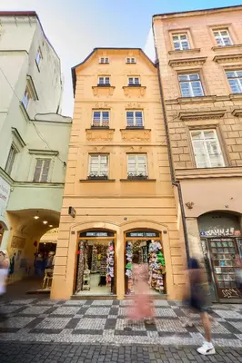 a person walking past a building in a street at NELIS I Boutique Apartments in Old Town in Prague