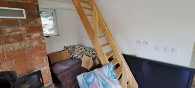 a staircase in a room with a couch and a tv at BohniceDrahanVltavaRelax in Zdiby