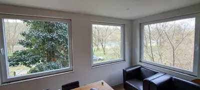 a living room with three windows and a chair at BohniceDrahanVltavaRelax in Zdiby